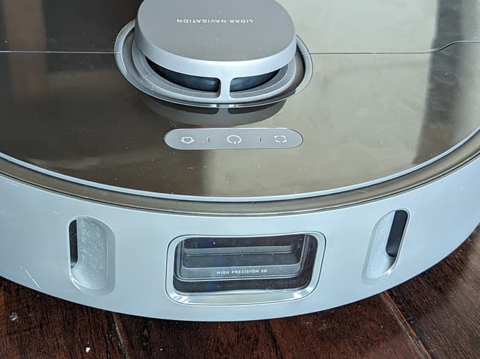 Close up of the front of a Z10 robot vacuum. A lidar sensor is peeking out of the otherwise flat top of the robot. On the front center, a clear plastic window lets a block of cameras look out. Either side of the camera block are two apertures for obstacle detection lasers.